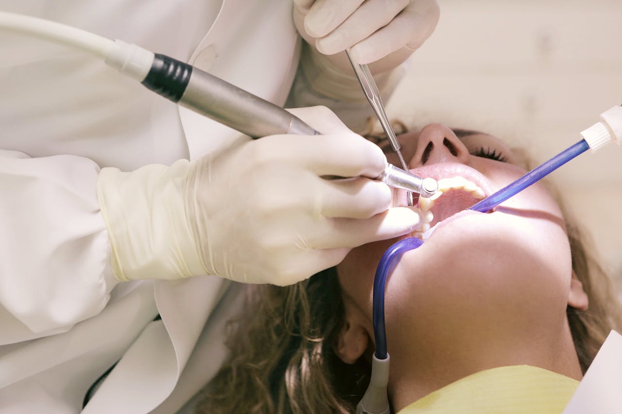 Close-up of a dental procedure with tools in a clinic setting, patient undergoing treatment.